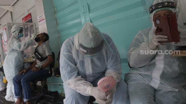Petugas kesehatan melakukan tes usap (swab test) PCR di Jakarta, Senin (25/10/2021). [Suara.com/Angga Budhiyanto]