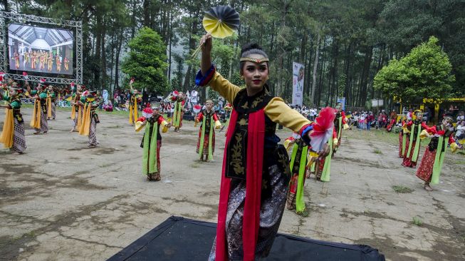 Penari mementaskan tarian Ibing Pencug Ewag pada gelaran Pentas Rakyat Puntang Menari di Camp Area Gunung Puntang, Kabupaten Bandung, Jawa Barat, Minggu (24/10/2021). [ANTARA FOTO/Novrian Arbi]