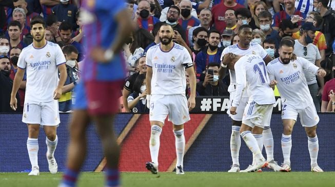 Pemain depan Real Madrid Lucas Vazquez (kedua kanan) merayakan gol kedua timnya selama pertandingan sepak bola Liga Spanyol antara FC Barcelona dan Real Madrid CF di stadion Camp Nou, Barcelona, Minggu (24/10/2021). [JOSEP LAGO / AFP]