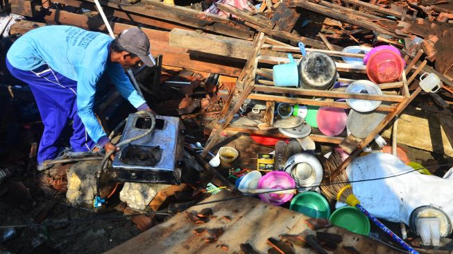 Warga menyelamatkan barang dari sisa reruntuhan rumah yang roboh akibat diterjang angin puting beliung di Desa Karanggeneng, Godong, Grobogan, Jawa Tengah, Selasa (26/10/2021). ANTARA FOTO/Yusuf Nugroho