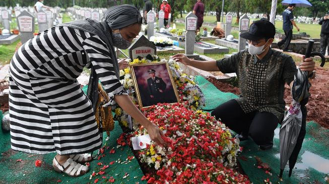 Kerabat menaburkan bunga di makam mantan Menteri Sekretaris Negara Sudi Silalahi di Taman Makam Pahlawan (TMP) Kalibata, Jakarta, Selasa (26/10/2021).  ANTARA FOTO/Hafidz Mubarak
