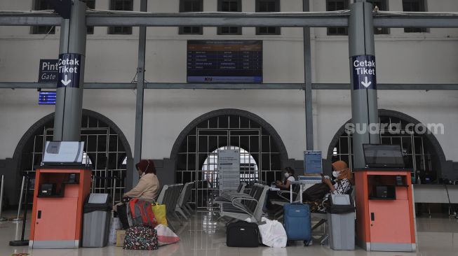 Calon penumpang menunggu kedatangan kereta di Stasiun Pasar Senen, Jakarta, Selasa (26/10/2021). [Suara.com/Angga Budhiyanto]