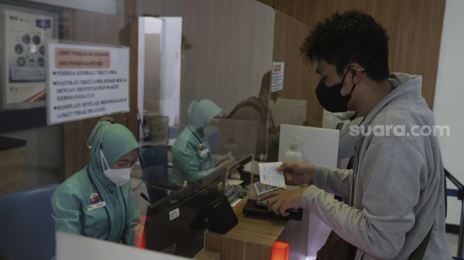 Calon penumpang membeli tiket kereta di Stasiun Pasar Senen, Jakarta, Selasa (26/10/2021). [Suara.com/Angga Budhiyanto]