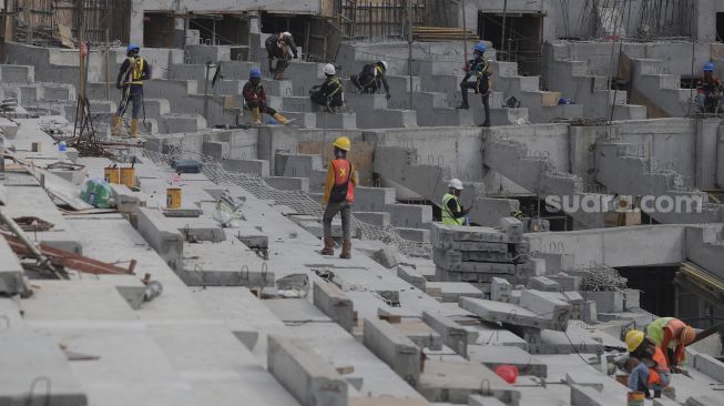 Pekerja menyelesaikan pembangunan Jakarta International Stadium (JIS) di Tanjung Priok, Jakarta, Selasa (26/10/2021). [Suara.com/Angga Budhiyanto]