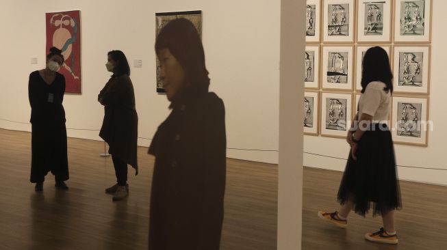 Kurator berdiri di dekat karya seni yang dipamerkan dalam pameran 'Semesta dan Angan' di Museum Modern and Contemporary Art in Nusantara (MACAN), Jakarta, Rabu (27/10/2021). [Suara.com/Angga Budhiyanto] 