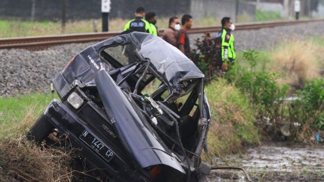 Polisi mengamankan Tempat Kejadian Perkara (TKP) kecelakaan kereta api yang menabrak mobil di perlintasan tanpa palang pintu di Sonotengah, Malang, Jawa Timur, Rabu (27/10/2021). ANTARA FOTO/Ari Bowo Sucipto