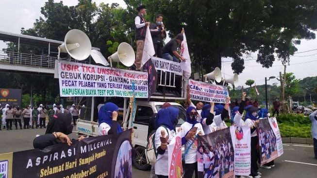 Diguyur Hujan Lebat, Ribuan Buruh dan Mahasiswa Demo Jokowi Tetap Bertahan