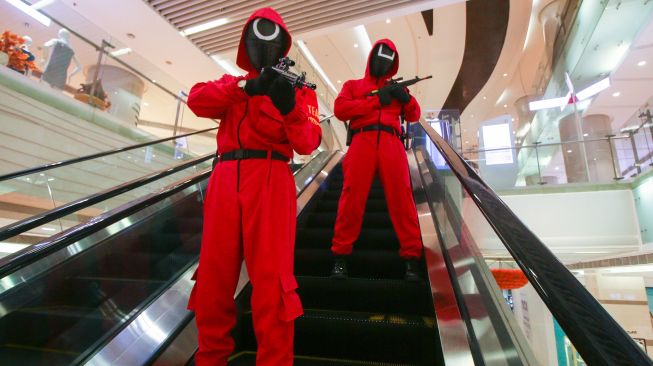 Petugas keamanan berkeliling dengan menggunakan kostum drama serial Squid Game di Lotte Shopping Avenue, Jakarta, Kamis (28/10/2021). ANTARA FOTO/Rivan Awal Lingga