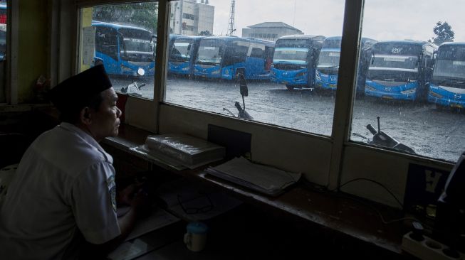 Petugas melihat sejumlah bus yang tidak beroperasi di pool (pangkalan) Bus Damri, Bandung, Jawa Barat, Kamis (28/10/2021). ANTARA FOTO/Novrian Arbi