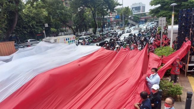 Hari Sumpah Pemuda, Massa Bentangkan Bendera Merah Putih Raksasa di Tengah Jalan