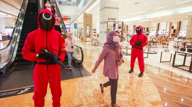 Petugas keamanan berkeliling dengan menggunakan kostum drama serial Squid Game di Lotte Shopping Avenue, Jakarta, Kamis (28/10/2021). ANTARA FOTO/Rivan Awal Lingga