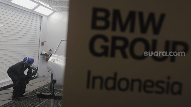 Teknisi melakukan proses perbaikan cat dan bodi mobil BMW saat peresmian Autoglad di Bengkel Autoglad, Jalan Raya Pekayon, Bekasi, Jawa Barat, Kamis (28/10/2021). [Suara.com/Angga Budhiyanto]