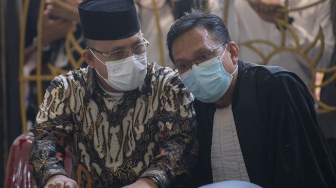 Terdakwa kasus suap sejumlah proyek di Kabupaten Muara Enim yang merupakan Bupati Kabupaten Muara Enim nonaktif Juarsah (kiri) berbincang dengan kuasa hukumnya sat menjalani sidang pembacaan putusan di Pengadilan Tipikor Palembang, Sumatera Selatan, Jumat (29/9/2021). ANTARA FOTO/Nova Wahyudi
