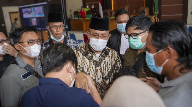 Terdakwa kasus suap sejumlah proyek di Kabupaten Muara Enim yang merupakan Bupati Kabupaten Muara Enim nonaktif Juarsah (tengah) berjabat tangan dengan keluarganya usai menjalani sidang pembacaan putusan di Pengadilan Tipikor Palembang, Sumatera Selatan, Jumat (29/9/2021). ANTARA FOTO/Nova Wahyudi
