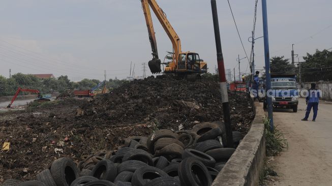 Petugas dari Suku Dinas Sumber Daya Air Jakarta Pusat mengoperasikan alat berat untuk melakukan pengerukan sedimen lumpur di sepanjang aliran Kanal Banjir Barat di kawasan Tanah Abang, Jakarta, Jumat (29/10/2021). [Suara.com/Angga Budhiyanto]