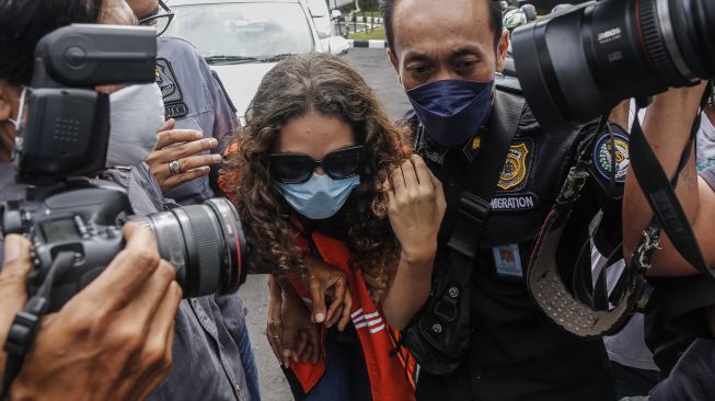 Warga negara Amerika Serikat, Heather Mack (tengah) digiring petugas imigrasi setelah memperoleh status bebas murni di Lapas Kerobokan, Badung, Bali, Jumat (29/10/2021).  ANTARA FOTO/Panji Anggoro