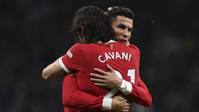 Striker Manchester United Edinson Cavani melakukan selebrasi dengan striker Manchester United Cristiano Ronaldo (kanan) setelah mencetak gol kedua mereka selama pertandingan sepak bola Liga Premier Inggris antara Tottenham Hotspur dan Manchester United di Stadion Tottenham Hotspu, London, Inggris, Sabtu (30/10/2021). [GLYN KIRK / AFP]