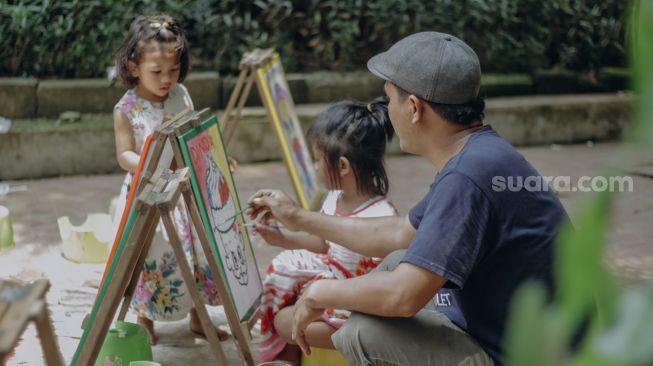 Orang tua mendampingi anaknya bermain di Taman Ekspresi, Karawaci, Kota Tangerang, Banten, Minggu (31/10/2021). [Suara.com/Hilal Rauda Fiqry]