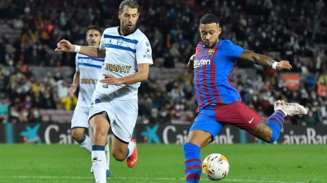 Bek Alaves Florian Lejeune (kiri) berusaha menghadang tendangan penyerang Barcelona Memphis Depay dalam pertandingan lanutan Liga Spanyol di Stadion Camp Nou, Barcelona, Spanyol, Sabtu (30/10/2021) waktu setempat. ANTARA/AFP/PAU BARRENA