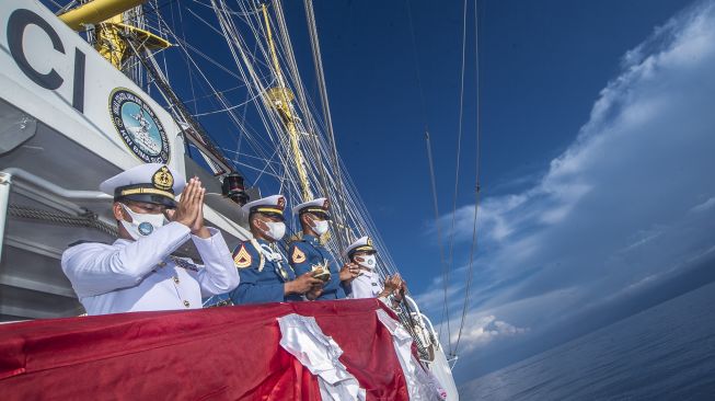 Komandan KRI Bima Suci Letkol Laut (P) Waluyo (kiri) bersama Perwira KRI Bima Suci dan Taruna Akademi Angkatan Laut (AAL) Tingkat III Angkatan ke-68 memanjatkan doa pada upacara tabur bunga di atas geladak KRI Bima Suci, Laut Bali, Bali, Minggu (31/10/2021). [ANTARA FOTO/Muhammad Adimaja]