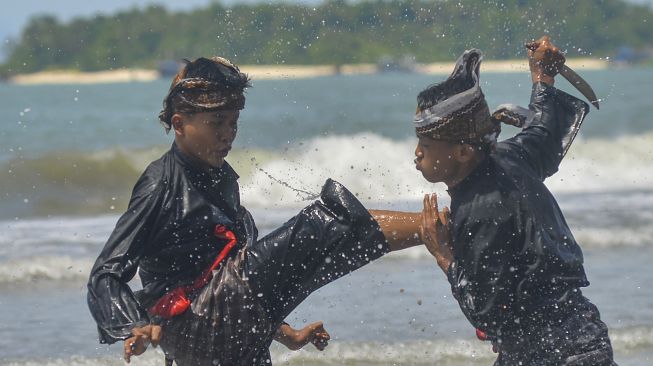 Peserta menampilkan atraksi silek saat Festival Silek on the Sea, di Pantai Kata, Pariaman, Sumatera Barat, Minggu (31/10/2021). [ANTARA FOTO/Iggoy el Fitra]