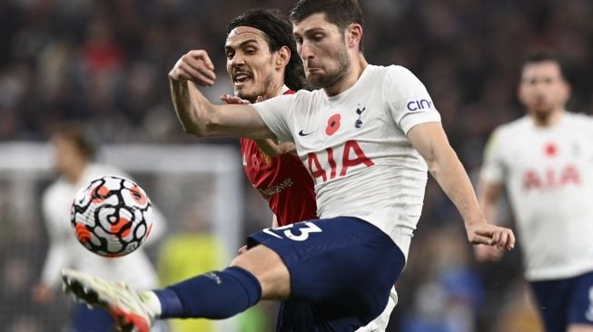 Striker Manchester United Edinson Cavani (kiri) bersaing dengan bek Tottenham Hotspur Ben Davies (kanan) selama pertandingan sepak bola Liga Premier Inggris antara Tottenham Hotspur dan Manchester United di Stadion Tottenham Hotspur, London, Inggris, Sabtu (30/10/2021). [GLYN KIRK / AFP]