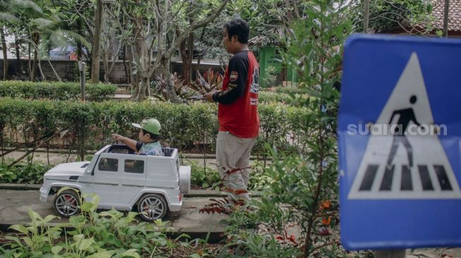 Orang tua mendampingi anaknya bermain di Taman Ekspresi, Karawaci, Kota Tangerang, Banten, Minggu (31/10/2021). [Suara.com/Hilal Rauda Fiqry]