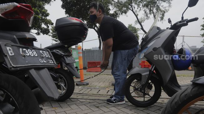 Petugas melakukan uji emisi gas buang kendaraan di Lapangan Parkir IRTI Monas, Jakarta, Senin (1/11/2021). [Suara.com/Angga Budhiyanto]