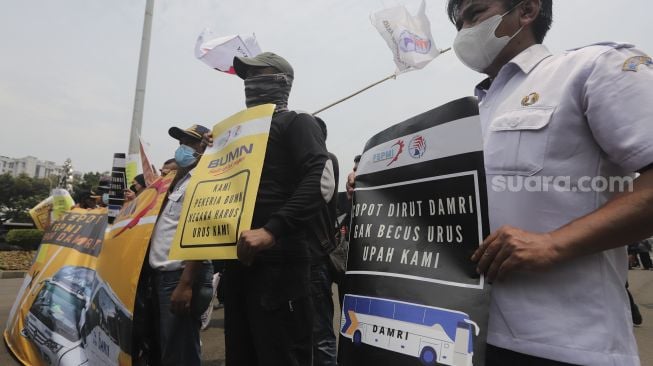 Sejumlah massa buruh membawa poster saat menggelar aksi unjuk rasa di kasawan Patung Kuda Arjuna Wiwaha, Jakarta, Senin (1/11/2021). [Suara.com/Angga Budhiyanto] 