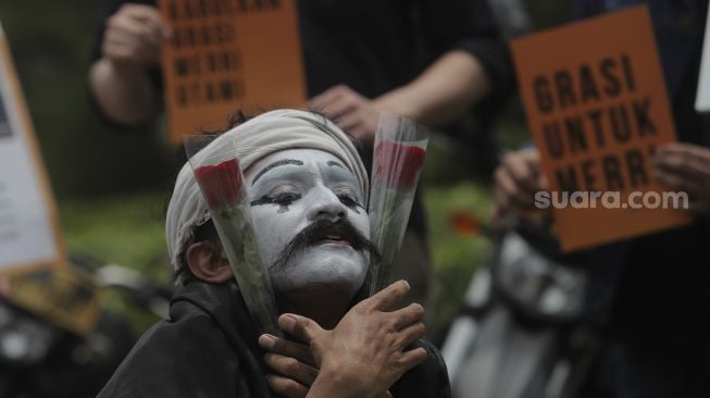 Relawan melakukan aksi teatrikal di kawasan Patung Kuda Arjuna Wiwaha, Jakarta, Senin (1/11/2021). [Suara.com/Angga Budhiyanto]