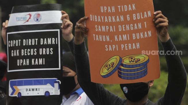 Sejumlah massa buruh membawa poster saat menggelar aksi unjuk rasa di kasawan Patung Kuda Arjuna Wiwaha, Jakarta, Senin (1/11/2021). [Suara.com/Angga Budhiyanto] 