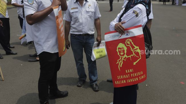 Sejumlah massa buruh membawa poster saat menggelar aksi unjuk rasa di kasawan Patung Kuda Arjuna Wiwaha, Jakarta, Senin (1/11/2021). [Suara.com/Angga Budhiyanto] 