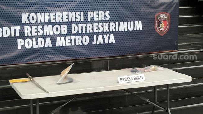 Subdit Resmob Ditreskrimum Polda Metro Jaya memperlihatkan barang bukti kasus perampokan dan pembacokan karyawati Basarnas di Mapolda Metro Jaya, Senin (1/11/2021). [Suara.com/Muhammad Yasir]