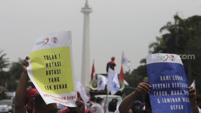 Sejumlah massa buruh membawa poster saat menggelar aksi unjuk rasa di kasawan Patung Kuda Arjuna Wiwaha, Jakarta, Senin (1/11/2021). [Suara.com/Angga Budhiyanto] 