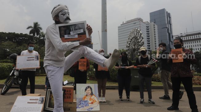 Relawan melakukan aksi teatrikal di kawasan Patung Kuda Arjuna Wiwaha, Jakarta, Senin (1/11/2021). [Suara.com/Angga Budhiyanto]