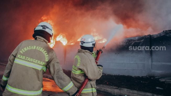 Sejumlah anggota pemadam kebakaran memadamkan api yang membakar pabrik korek api di kawasan Laksana Business Park, Kabupaten Tangerang, Banten. Selasa (2/11).   [Suara.com/Hilal Rauda Fiqry]