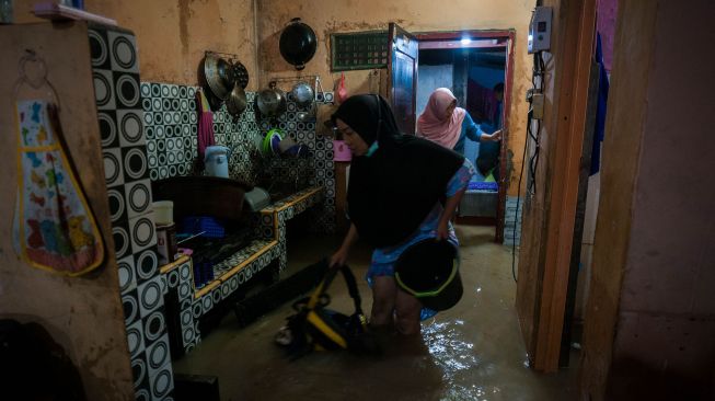 Warga menyelamatkan barang-barang yang terendam banjir di Rangkasbitung, Lebak, Banten, Senin (1/11/2021).  ANTARA FOTO/Muhammad Bagus Khoirunas