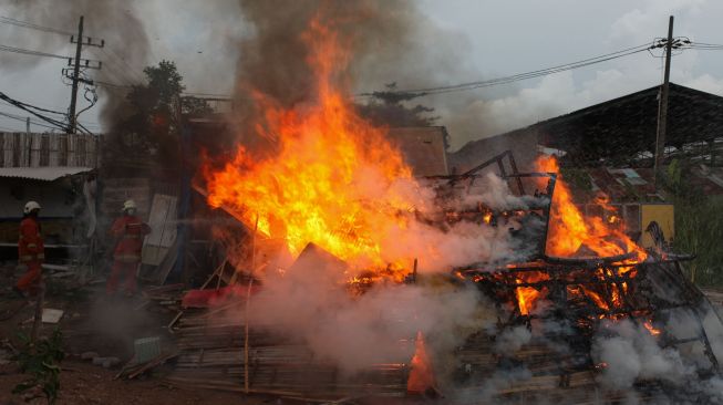 Petugas Dinas Pemadam Kebakaran Kota Surabaya memadamkan kandang burung merpati aduan yang dibakar usai dibongkar di kawasan Karang Asem, Surabaya, Jawa Timur, Senin (1/11/2021).  ANTARA FOTO/Didik Suhartono