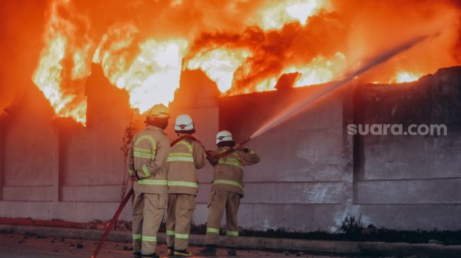 Sejumlah anggota pemadam kebakaran memadamkan api yang membakar pabrik korek api di kawasan Laksana Business Park, Kabupaten Tangerang, Banten. Selasa (2/11).   [Suara.com/Hilal Rauda Fiqry]