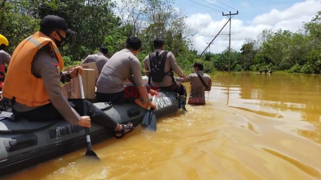 Warga dan Petugas terpaksa menggunakan sampan sebagai salah satu transportasi yang dapat digunakan akibat banjir di Kabupaten Melawi. [Suarakalbar.co.id/Dea Kusumah]