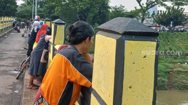 Sejumlah warga tengah menyaksikan petugas tim SAR gabungan yang sedang melakukan pencarian bocah Andika Budi Prasetyo (9) yang hanyut di Phb Robusta Duren Sawit di aliran BKT, Pondok Kopi, Jakarta Timur, Rabu (3/11/2021). [Suara.com/Yaumal Asri Adi Hutasuhut]