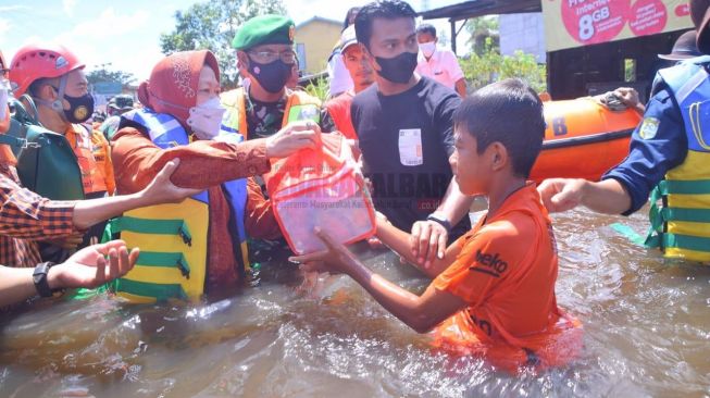 Mensos Risma saat memberikan bantuan kepada warga yang terdampak banjir di Kabupaten Sintang, Rabu (3/11/2021). [Dok.Suarakalbar.co.id]