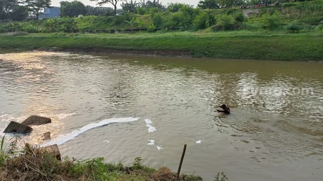 Pencarian bocah hanyut di Banjir Kanal Timur, Pondok Kopi, Jaktim menjadi tonton warga. (Suara.com/Yaumal)