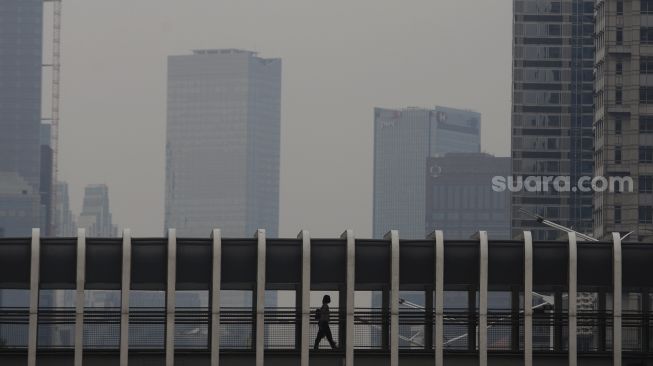 Pekerja menaiki jembatan penyeberangan orang (JPO) saat jam pulang kerja di Jalan Jenderal Sudirman, Jakarta, Rabu (3/11/2021). [Suara.com/Angga Budhiyanto]