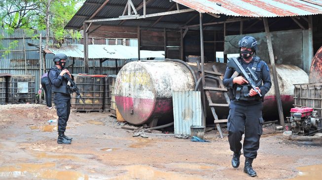 Polisi berjaga saat razia tempat pengoplosan minyak mentah ilegal di Mendalo Darat, Jambi Luar Kota, Muarojambi, Jambi, Rabu (3/11/2021). ANTARA FOTO/Wahdi Septiawan