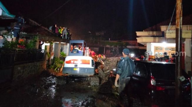 Pencarian warga yang terpendam di rumahnya yang hancur terdampak banjir bandang Kota Batu, Kamis (4/11/2021) malam. [Suara.com/Bob Bimantara Leander]