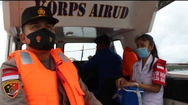 Kapolres Nias Selatan AKBP Reinhard Habonaran Nainggolan bersama tim vaksinator Polres Nias Selatan naik kapal menuju pulau terluar Kabupaten Nias. [Ist]
