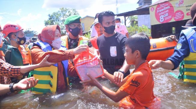 Menteri Sosial RI Tri Rismaharini saat memberikan bantuan kepada warga yang terdampak banjir di Kabupaten Sintang, Rabu (3/11/2021). [Suarakalbar.co.id]