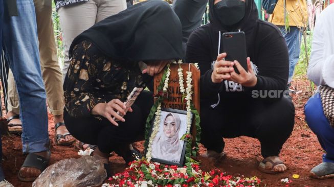 Keluarga berdoa diatas pusara Vanessa Angel dan Suaminya, Bibi Ardiansyah usai dimakamkan di Taman Makam Islam Malaka, Pesanggrahan, Jakarta Selatan, Jumat (5/11/2021). [Suara.com/Alfian Winanto]
