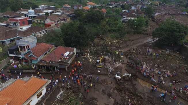 Foto udara Tim SAR gabungan bersama relawan dan warga membersihkan endapan lumpur saat pencarian korban akibat banjir bandang di Bulukerto, Kota Batu, Jawa Timur, Jumat (5/11/2021).  ANTARA FOTO/Zabur Karuru